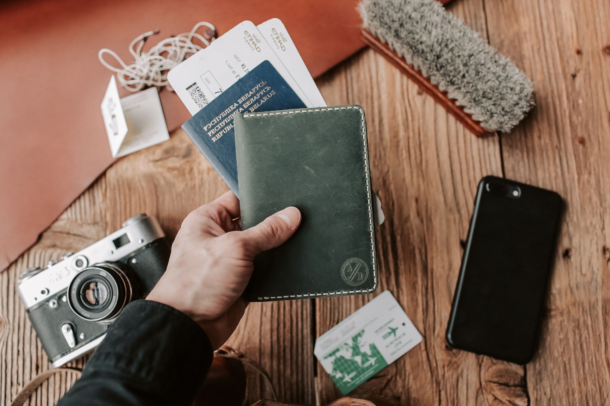 Travel documents and a phone on a wooden table