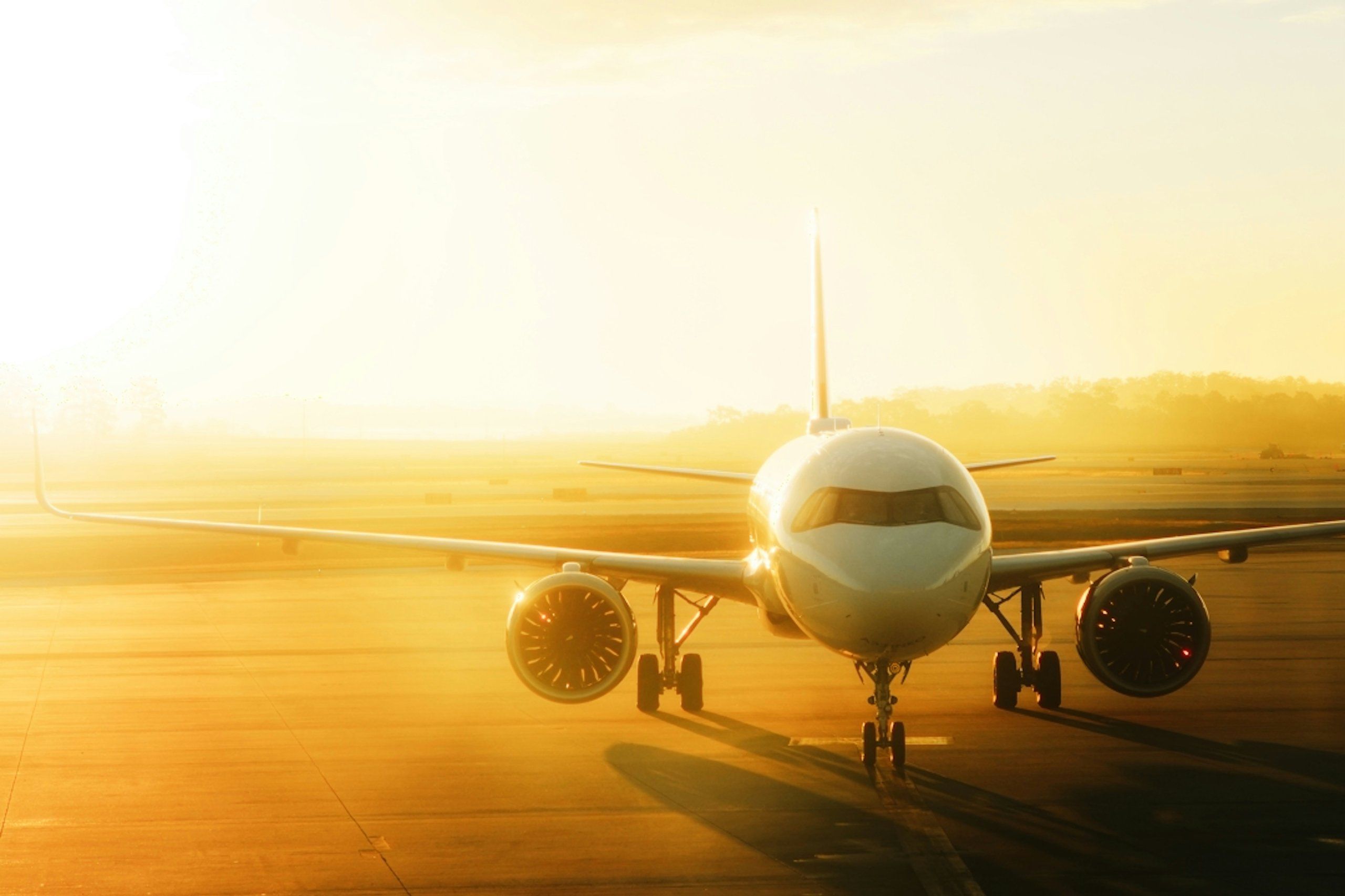 A passenger plane on the runway at sunrise